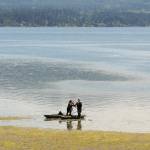Juli Sias of Sequim, left, passes her grandson, Nathanael Sias, 1, to her son, Landon Sias, after the family spent time kayaking on the waters of Sequim Bay east of Sequim on Wednesday. The trio found the adventure a good way to beat the heat of a stretch of unseasonably warm temperatures across much of the North Olympic Peninsula. (Keith Thorpe/Peninsula Daily News)