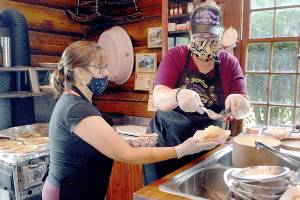 Keith Thorpe/Peninsula Daily News
Festival server Rebbecca Paradis, left, prepares to serve slices of blackberry pie being doled out by Rachael Wood in the kitchen of the Joyce Depot during the 2021 Joyce Daze Wild Blackberry festival.