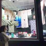 Abbey Engrav, visiting Port Townsend from New York City for her brothers wedding on Saturday, looks at the vintage Japanese garments and shoes on display at the Peninsula Fiber Artists display window on Tyler Street in the Uptown Neighborhood on Friday night. (Steve Mullensky/for Peninsula Daily News)