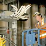 Randy Frantz of Bremerton-based Miller Sheetmetal Inc. works on overhead interior piping on Tuesday at the Field Arts & Events Hall in Port Angeles. (Keith Thorpe/Peninsula Daily News)