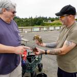 Scott Miller, left, of Silverdale points to the undersized rock crab that Tom Price of Spanaway is holding. Both men were crabbing off the Marine Science Center pier at Fort Worden on Thursday. The other crab was barely legal size, and Price put both back into the sea. (Steve Mullensky/for Peninsula Daily News)