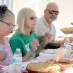 Blackberry pie judges, from left, Blackberry Cafe owner Roxanne Olsen, former Port Angeles Mayor Cherie Kidd and Peninsula Daily News publisher Terry Ward watch as another contest entry is presented to them on Saturday. (Keith Thorpe/Peninsula Daily News)