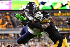 Seattle Seahawks running back DeeJay Dallas (31) leaps to the end zone for a touchdown as Pittsburgh Steelers linebacker Buddy Johnson (45) hits him during the second half of an NFL preseason football game Saturday, Aug. 13, 2022, in Pittsburgh. (AP Photo/Barry Reeger)