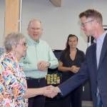 U.S. Rep. Derek Kilmer shakes hands with Diana Walter-Lopez, Port Angeles Food Bank board secretary. Behind her is Kelly Fisher, board treasurer. In the background is Alexi Nelson of the Food Bank staff. (Dave Logan/for Peninsula Daily News)