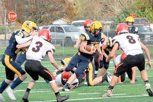 Forks' Nate Dahlgren makes his cut between Wahkiakum defenders in Forks during a playoff game in November 2021. Dahlgren scored a pair of touchdowns in the win. (Lonnie Archibald/for Peninsula Daily News)