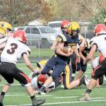 Forks Nate Dahlgren makes his cut between Wahkiakum defenders in Forks during a playoff game in November 2021. Dahlgren scored a pair of touchdowns in the win. (Lonnie Archibald/for Peninsula Daily News)