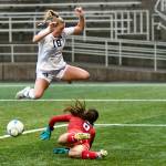 Jay Cline/for Peninsula College Peninsula Colleges Kyrsten McGuffey hurdles Columbia Basin goalkeeper RiaJo Schwartz during the first half of the Pirates 2-1 come-from-behind win over the Hawks in the NWAC Semifinals on Friday at Starfire Sports Stadium.