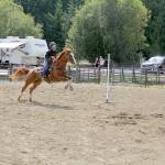 Cassie Moores horse Louis jumps over the white line at the start of her pole bending run during the 4-H games show (as an adult in the Open class) at the Jeffco Fair on Aug. 8. 4-H horse rules dictate a white line be placed at the start/finish line which often confuses the horse. (Karen Griffiths/For Peninsula Daily News)
