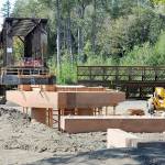 A construction crew prepares support structures for a new elevated walkway that will link the historic railroad trestle to the Dungeness River Nature Center at Railroad Bridge Park in Sequim and the existing Olympic Discovery Trail. The work is part of a project to restore the floodplain of the Dungeness River while providing improved access to the plaza of the recently opened nature center. The new walkway will include a bypass span, providing a direct route for pedestrians and bicyclists using the trail. Work is expected to be completed this fall. (Keith Thorpe/Peninsula Daily News)