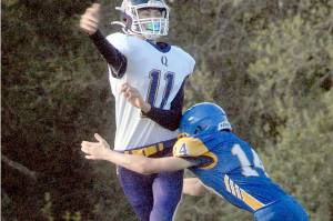Quilcene quaterback Nathan Kieffer passes before being tackled by Crescents Cole Grooms on Thursday at Crescent High School. (Keith Thorpe/Peninsula Daily News)