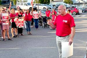 Members of the Port Angeles Education Association and its president John Henry, right, rallied at the Port Angeles School Districts Lincoln Center administrative building Wednesday evening just hours before the union called for a strike to begin Tuesday if an agreement is not reached. (Paula Hunt/Peninsula Daily News)
