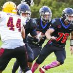 The Rivals’ Gary Zambor (1) holds off Kingston’s Aaron Fitsemons (44), as Charly Schweitzer (78) and Sean Jones (76) provide protection for quarterback Cash Holmes, during a game against the Kingston Buccaneers on Friday at Memorial Field in Port Townsend. (Steve Mullensky/for Peninsula Daily News)