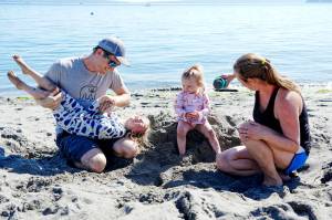 The Irick family  dad Chance, daughters Maeve, 4, and June, 18 months, and mom Sarah, all from Port Townsend  spend the last day of summer vacation at the beach at Fort Worden State Park on Monday. Maeve starts school today. (Steve Mullensky/for Peninsula Daily News)
