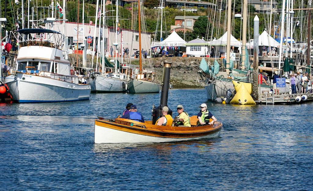 Puffin, a 1906 steam launch, takes passengers for a free ride in Port Townsend Bay during the 45th Wooden Boat Festival at Point Hudson Marina on Friday. The Puffin was originally built as a gasoline launch but converter to steam power in the 1970s. The little boiler burns wood to make the steam. (Steve Mullensky/for Peninsula Daily News)