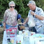 KEITH THORPE/PENINSULA DAILY NEWS
Marlene McCurdy of Port Angeles, left, purchases coffee mugs from Gary Gort of Port Angeles at a sale table in front of the Crescent Grange Hall in Joyce on Saturday. The location was one of dozens of garage and yard sales taking part in the Great Strait Sale, stretching along and near State Highway 112 from Port Angeles to Neah Bay.