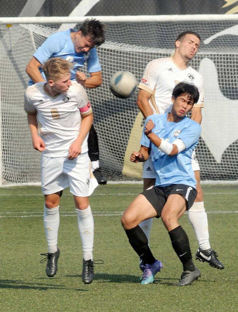 Peninsulas Tim Deser, front left, and Kai Biegler, rear right, fight for a header with Pierces Christian Mago, front right, and Andres Perez-Solis, rear left, on Saturday at Wally Sigmar Field in Port Angeles. (Keith Thorpe/Peninsula Daily News)