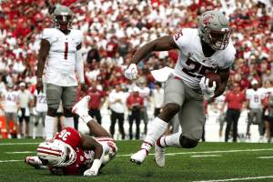 Washington State's Nakia Watson (25) runs past Wisconsin's Jake Chaney (36) during the first half of an NCAA college football game Saturday in Madison, Wis. (AP Photo/Morry Gash)