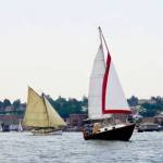 Sailboats cruise by the downtown area of Port Townsend to end the 45th Wooden Boat Festival at Point Hudson Marina on Sunday. (Steve Mullensky/for Peninsula Daily News)