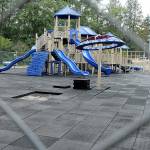 Fencing surrounds the playground at Shane Park in Port Angeles after parks department officials closed the equipment because of play surface tiles that are shrinking and becoming dislodged. (Keith Thorpe/Peninsula Daily News)