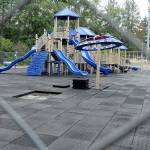 Fencing surrounds the playground at Shane Park in Port Angeles after parks department officials closed the equipment because of play surface tiles that are shrinking and becoming dislodged. (Keith Thorpe/Peninsula Daily News)