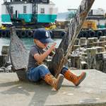 Max Albert Ruffo, 4½ from Port Townsend, rides the anchor fluke like a bucking bronco while visiting Point Hudson with his grandma on Tuesday. (Steve Mullensky/for Peninsula Daily News)