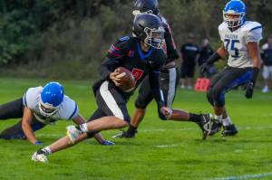 Rivals QB Cash Holmes eludes a South Whidbey defender and looks for a receiver downfield during a game Friday night at Memorial Field in Port Townsend.