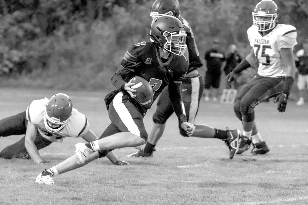 Steve Mullensky/for Peninsula Daily News

Rivals’ QB Cash Holmes eludes a South Whidbey defender and looks for a receiver downfield during a game Friday night at Memorial Field in Port Townsend.