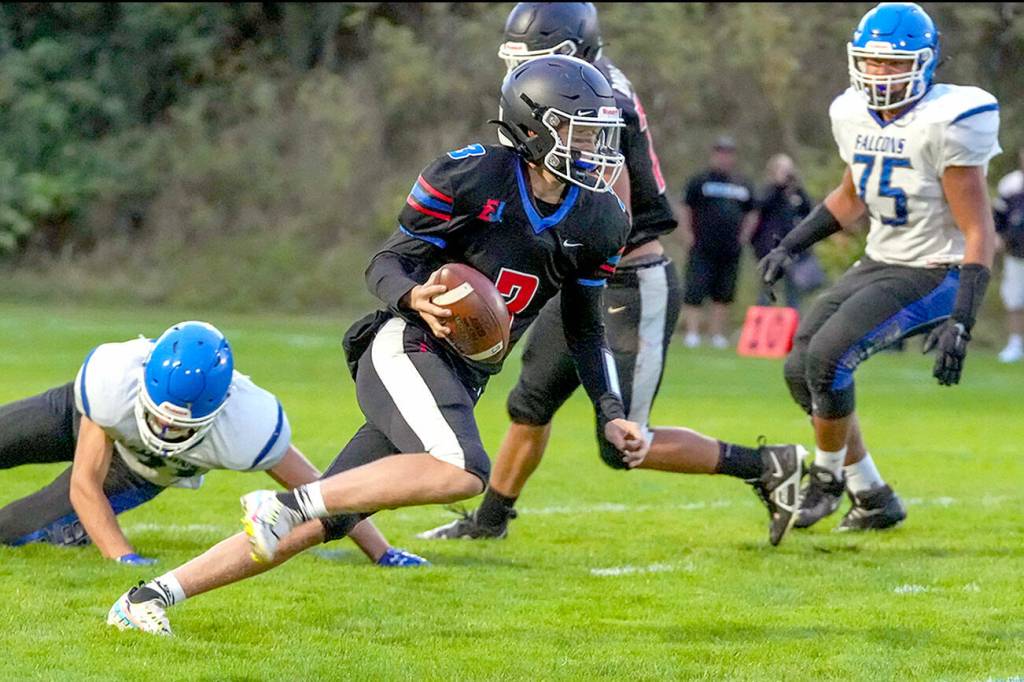 Steve Mullensky/for Peninsula Daily News

Rivals’ QB Cash Holmes eludes a South Whidbey defender and looks for a receiver downfield during a game Friday night at Memorial Field in Port Townsend.