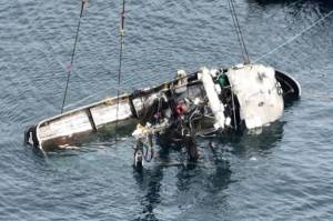 The Aleutian Isle lays on its side suspended by crane after being lifted to the surface on Saturday. (Canada Dept. of Fisheries and Oceans)