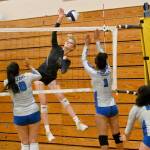 Sequim senior Kendall Hastings looks to hit past Olympics Erika Caryharius, left, and Aviyah Blackwell in a league match-up Tuesday in Sequim. (Michael Dashiell/Olympic Peninsula News Group)
