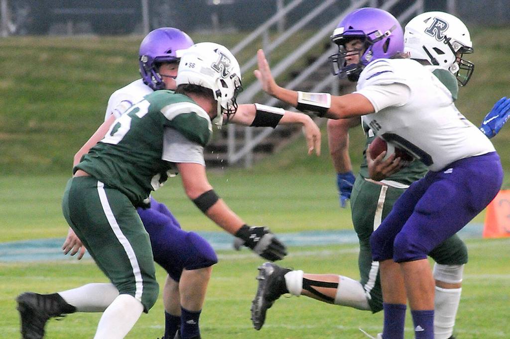 KEITH THORPE/PENINSULA DAILY NEWS
Sequim quarterback Lars Wiker, right, fends of the defense of Port Angeles' Tanner Flores on Friday night in Port Angeles.