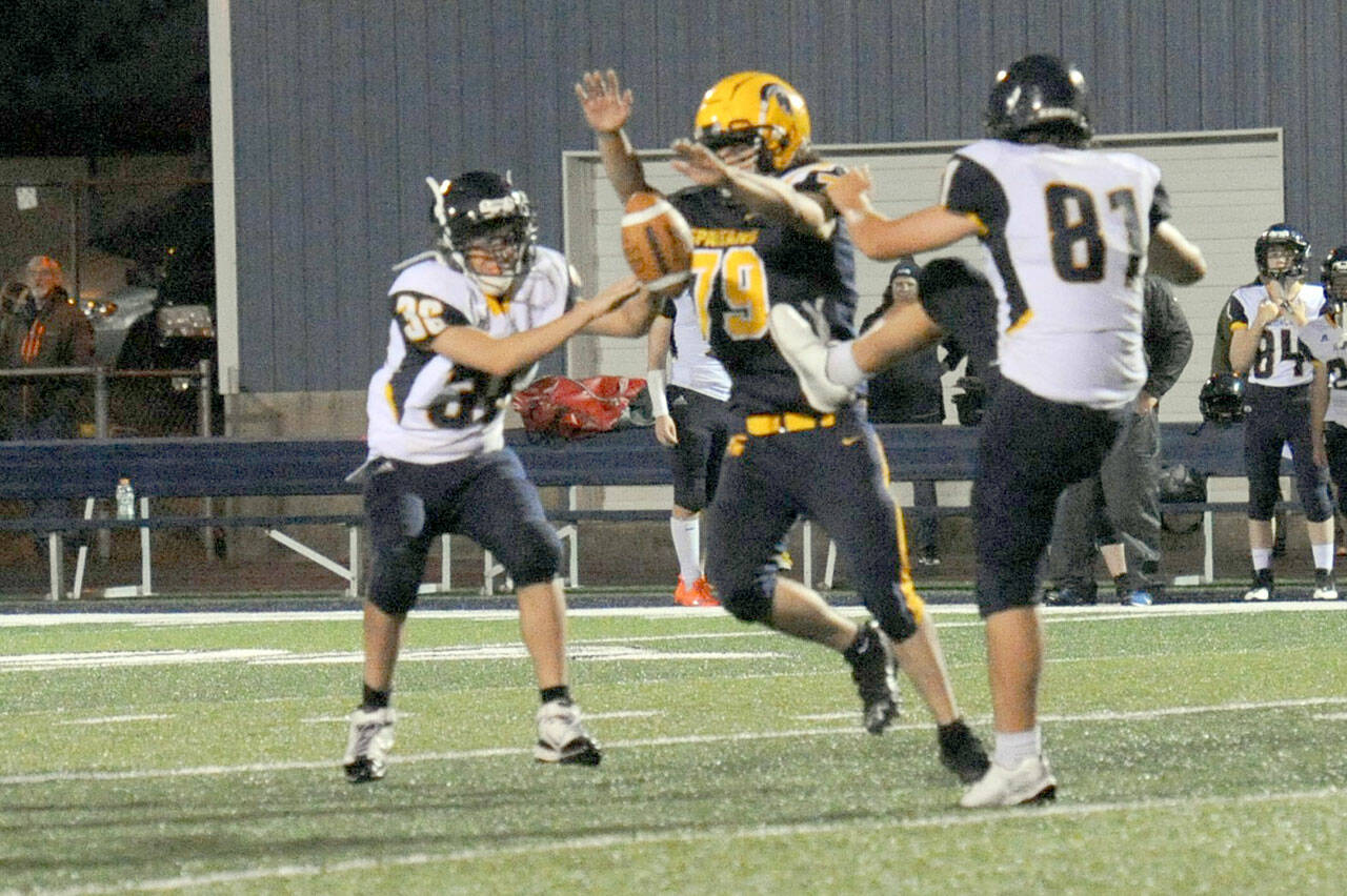 Forks Casimir Pullen (79) blocked this Ilwaco punt by Josh Wall (81) at Spartan Field on Friday night. It was a tough defense displayed all evening by Forks as the Spartans allowed just six points. (Lonnie Archibald/for Peninsula Daily News)
