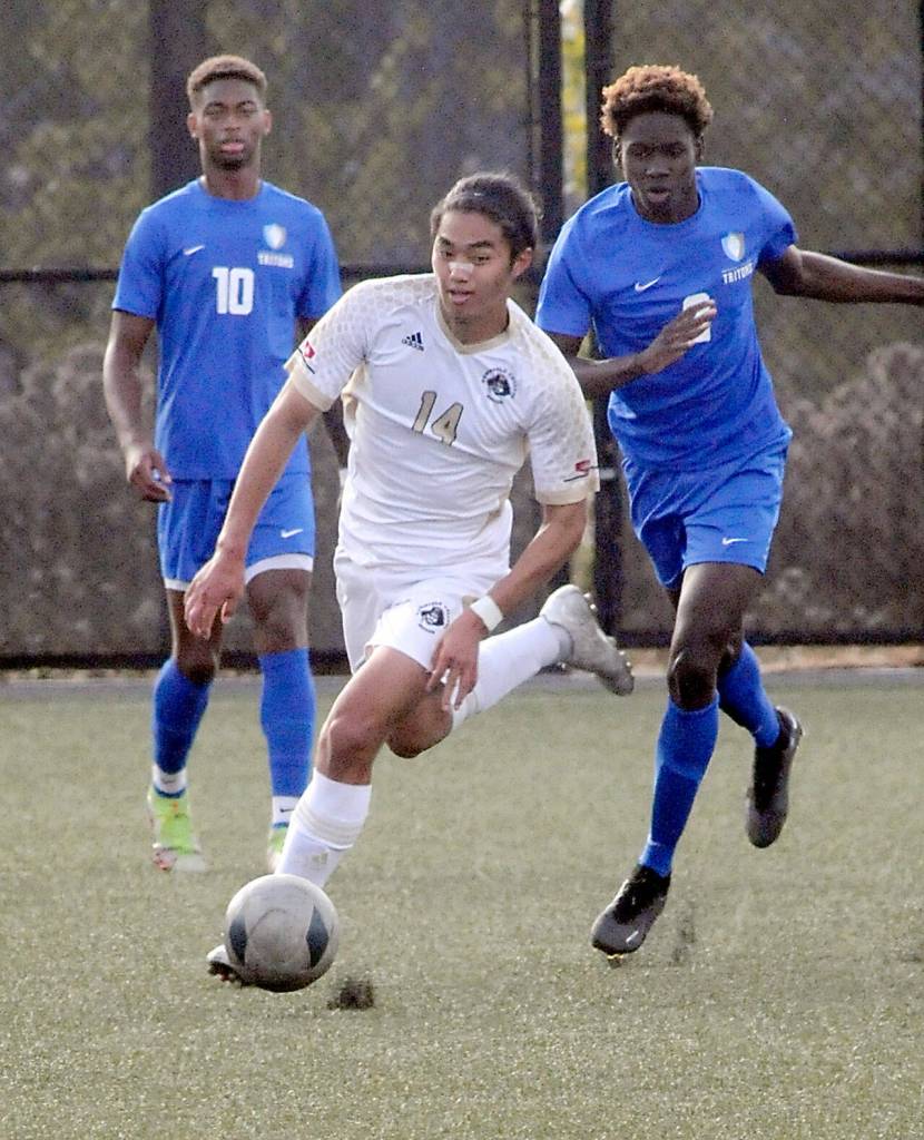 Peninsulas Shu Kato, center, advances downfield pursued by Edmonds Amadou Jadama, right, as Trevon Hamilton of Edmonds, left, watches from behind on Wednesday in Port Angeles. (Keith Thorpe/Peninsula Daily News)