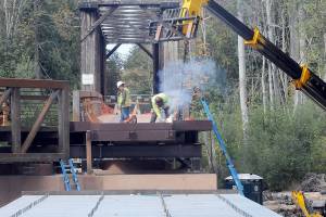 KEITH THORPE/PENINSULA DAILY NEWS
A construction worker welds support pieces for a new pedestrian bridge connecting the historic railroad trestle over the Dungeness River to the Dungeness River Nature Center at Railroad Bridge Park in Sequim on Wednesday. The work is part of a project to restore part of the original Dungeness River floodplain while providing better access to the Olympic Discovery Trail.