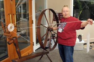 Rocky Wisniewski of Sequim, a member of the North Olympic Shuttle Spindle Guild, demonstrates how to spin fiber on a walking wheel during Saturdays Pacific Northwest Fiber Exposition at Vern Burton Community Center in Port Angeles. The two-day event featured a wide variety of demonstrations, exhibits, workshops and a marketplace showcasing all things fiber. (Keith Thorpe/Peninsula Daily News)