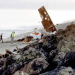 Broken wreckage of the cabin cruiser Eudora is hoisted by helicopter from the beach on Ediz Hook in Port Angeles on Wednesday as a crew hired by the state Department of Natural Resources gathers pieces of the shipwrecked vessel. (Keith Thorpe/Peninsula Daily News)