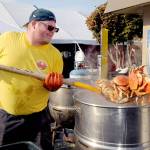 Crab crew member Jacob Brown of Port Angeles pulls cooked crab from a boiler on Thursday in preparation for the opening of the Dungeness Crab and Seafood Festival on the Port Angeles waterfront. The three-day festival begins today and runs through Sunday. For more information, see Page A6. (Keith Thorpe/Peninsula Daily News)