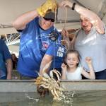 Elaina Wood, 6, center, looks on in delight after catching a crab as her brother, Kjol Wood, 11, left, watches while grandmother Tina Taylor of Port Angeles, right, and Puget Sound Anglers member Russ Manson of Sequim assist with the capture during the Grab a Crab Derby on Saturday at the Dungeness Crab and Seafood Festival in Port Angeles. The three-day festival brought abut 15,000 people to the Port Angeles waterfront for food, music and other activities. (Keith Thorpe/Peninsula Daily News)