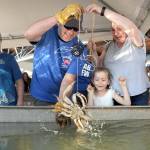 Elaina Wood, 6, center, looks on in delight after catching a crab as her brother, Kjol Wood, 11, left, watches while grandmother Tina Taylor of Port Angeles, right, and Puget Sound Anglers member Russ Manson of Sequim assist with the capture during the Grab a Crab Derby on Saturday at the Dungeness Crab and Seafood Festival in Port Angeles. The three-day festival brought abut 15,000 people to the Port Angeles waterfront for food, music and other activities. (Keith Thorpe/Peninsula Daily News)