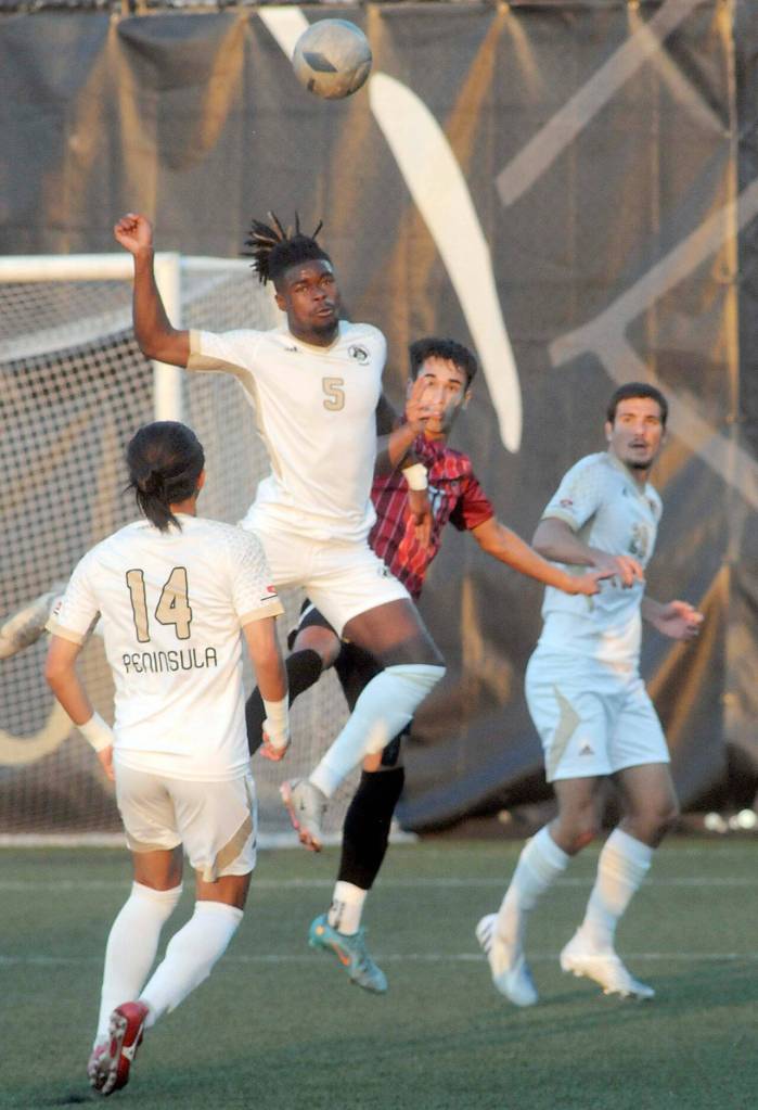 Peninsulas Dylan Pauw accepts the header over the defense of Everetts Oliver Giessler while Pauws teammates Shu Kato, left, and Hadrien Pena keep watch on Saturday in Port Angeles. (Keith Thorpe/Peninsula Daily News)
