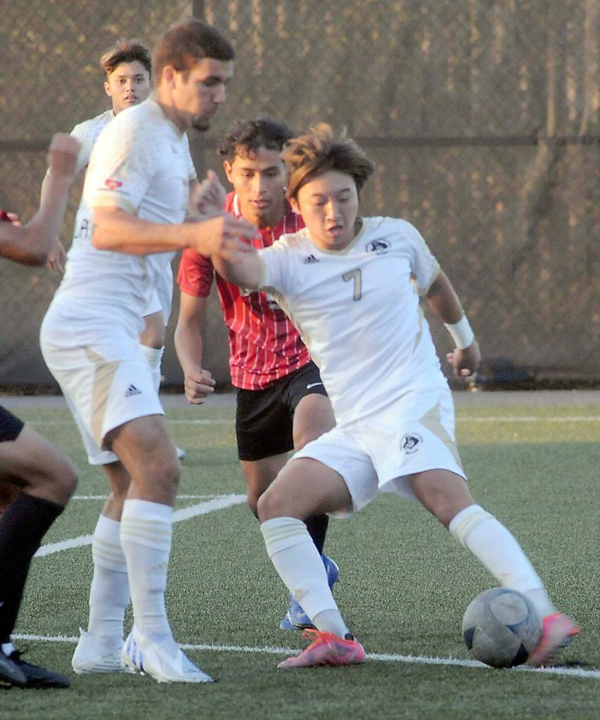Peninsulas Inchun Han, left, sets up for a pass with teammate Kai Biegler standing guard while Everetts Jesus Criaco-Trujillo tries to break up the play on Saturday in Port Angeles. (Keith Thorpe/Peninsula Daily News)