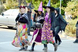 From left, Nancy Mandell, Julia Escobedo and Mandy Escobedo partake in the inaugural Witches Walk through downtown Port Townsend on Saturday. Some 50 witches  women, children and men among them  assembled at Haller Fountain and sashayed through traffic to Pope Marine Park. (Diane Urbani de la Paz/For Peninsula Daily News)