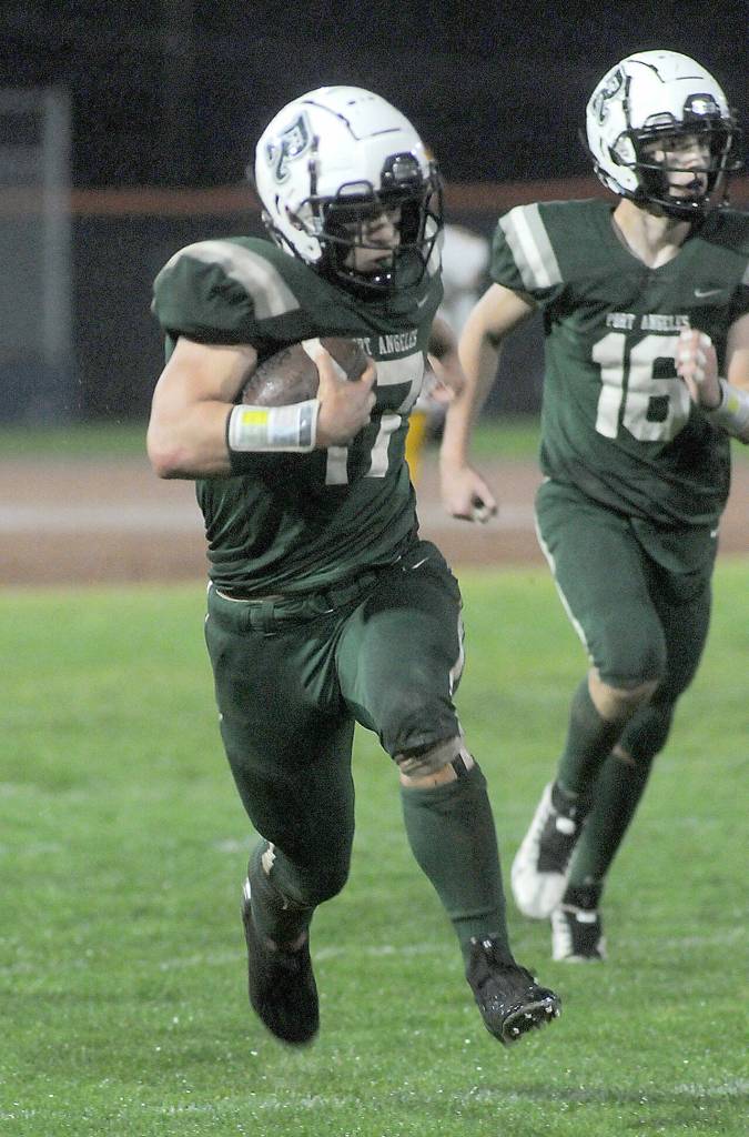 Port Angeles Jason Hawes, left, takes a punt return from deep in Roughrider territory for a second quarter touchdown against Kingston as teammate Blake Sohlberg follows behind on Friday at Port Angeles Civic Field. (KEITH THORPE/PENINSULA DAILY NEWS)