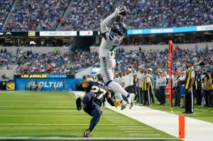 Seattle Seahawks wide receiver Marquise Goodwin (11) catches a pass for a touchdown during the first half of an NFL football game against the Los Angeles Chargers Sunday, Oct. 23, 2022, in Inglewood, Calif. Los Angeles Chargers cornerback J.C. Jackson (27) falls with an injury. (AP Photo/Marcio Jose Sanchez)