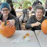 Kathy Durr, 70, left, and Charle Crocker, 69, both of Port Angeles, try their hands at carving jack-o-lanterns during a pumpkin carving workshop on Saturday at the Port Angeles Fine Arts Center. The workshop, which drew about 50 participants, was part of the centers second annual Celebration of Shadows, a tribute to the season of Halloween. The event also included a mask-making workshop, a carved pumpkin contest, spooky walks and an outdoor movie. (Keith Thorpe/Peninsula Daily News)