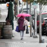 A pedestrian makes their way down West First Street as rain falls upon downtown Port Angeles on Tuesday. A return to seasonal wet weather has prompted county officials to end the annual summer burn ban that had been extended into fall because of exceptionally dry conditions. (Keith Thorpe/Peninsula Daily News)