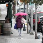 A pedestrian makes their way down West First Street as rain falls upon downtown Port Angeles on Tuesday. A return to seasonal wet weather has prompted county officials to end the annual summer burn ban that had been extended into fall because of exceptionally dry conditions. (Keith Thorpe/Peninsula Daily News)