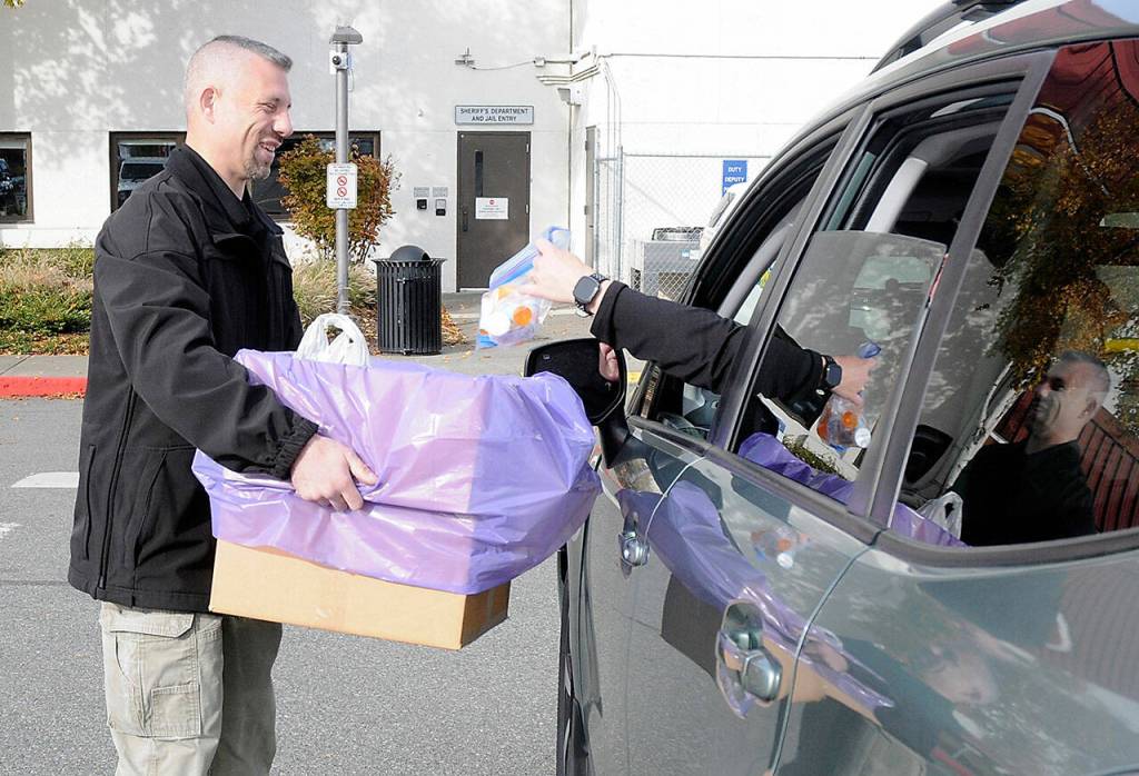 Inspector Josh Ley of the Clallam County Sheriffs Office accepts a package of medications from a motorist at the Clallam County Courthouse in Port Angeles during National Prescription Drug Take Back Day on Saturday. The nationwide event was developed to provide a safe method of disposing of unwanted, uneeded or expired prescription medications and illicit drugs. (Keith Thorpe/Peninsula Daily News)