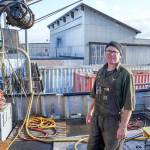 Blaise Holly, new owner of Haven Boatworks at the Boat Haven in Port Townsend, is on board the Molly, a commercial boat his company is servicing. In the background is Integrated Marine Systems, a building to which Holly will be re-locating soon. (Steve Mullensky/for Peninsula Daily News)