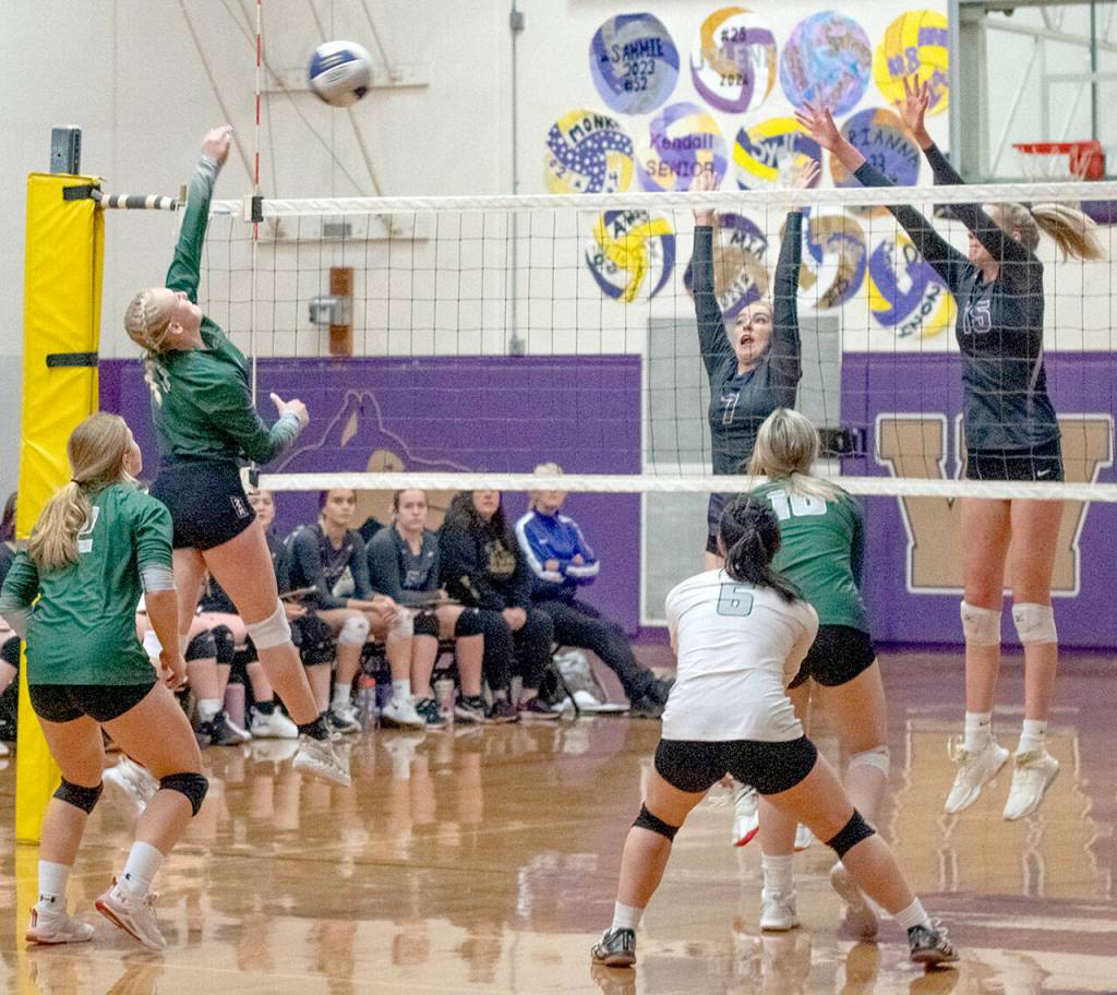 Emily Matthiessen/Olympic Peninsula News Group Port Angeles Alaina Baublitz, left, looks to hit past the block of Sequims Sydney Clark, center, and Kendall Hastings in an Olympic League tournament game on Nov. 3 in Sequim. The host Wolves topped PAs Roughriders in three games.